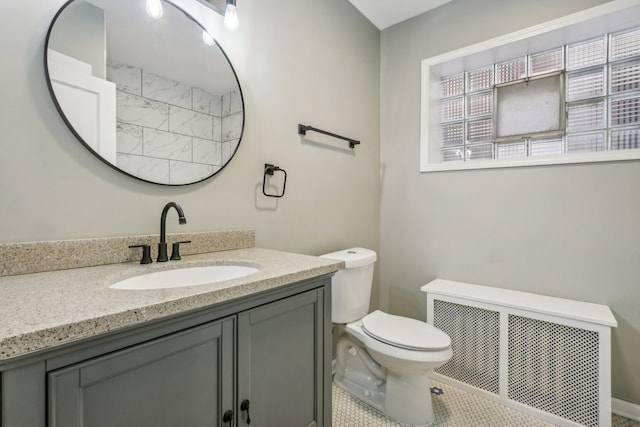 bathroom with tile patterned flooring, vanity, toilet, and radiator