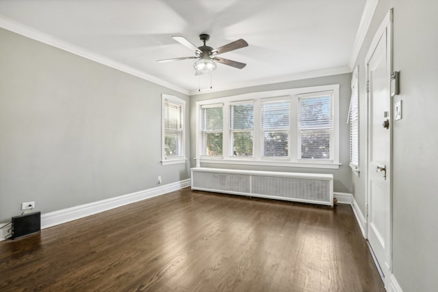 spare room with dark hardwood / wood-style floors, plenty of natural light, radiator, and ornamental molding