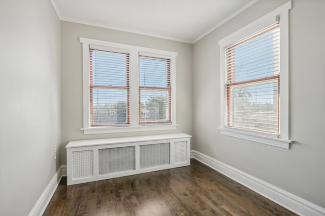 empty room featuring radiator heating unit, crown molding, and dark hardwood / wood-style flooring