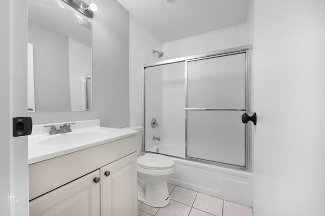 full bathroom featuring tile patterned flooring, vanity, bath / shower combo with glass door, and toilet