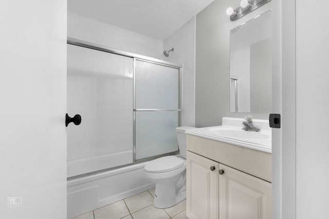 full bathroom with tile patterned flooring, vanity, combined bath / shower with glass door, and toilet