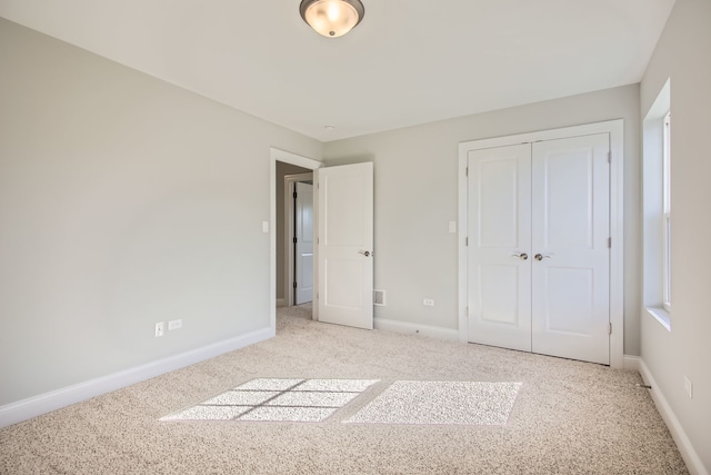 unfurnished bedroom featuring a closet and light colored carpet