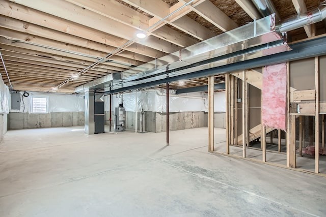 basement featuring electric panel and water heater