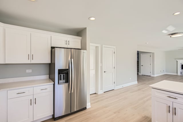 kitchen with white cabinetry, light wood-type flooring, and stainless steel fridge with ice dispenser