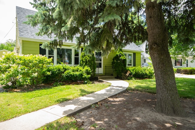 view of property hidden behind natural elements featuring a front lawn