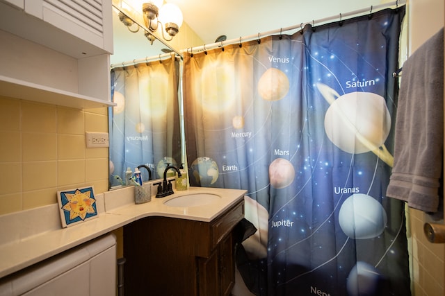 bathroom with vanity, backsplash, and curtained shower