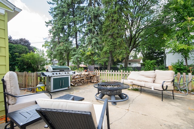 view of patio with area for grilling and an outdoor living space with a fire pit