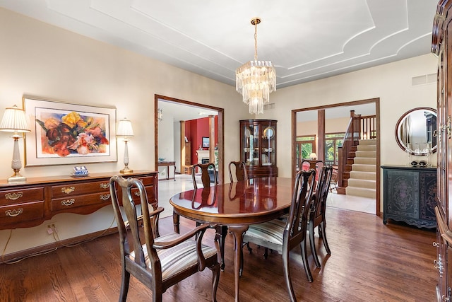 dining space featuring an inviting chandelier and dark hardwood / wood-style flooring