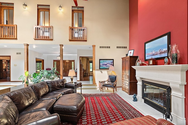 tiled living room with ornate columns and a high ceiling