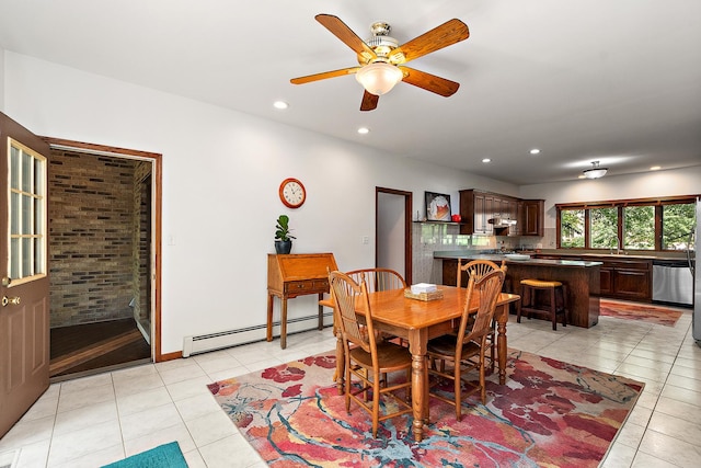 tiled dining space featuring brick wall, a baseboard heating unit, and ceiling fan