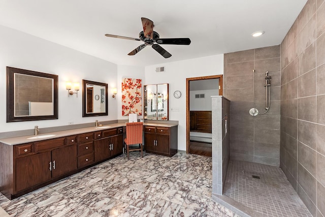 bathroom with vanity, a tile shower, and ceiling fan