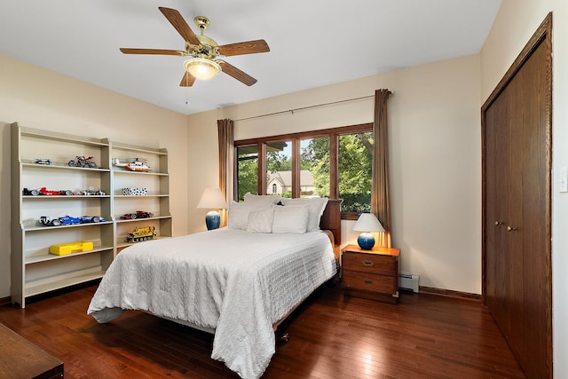 bedroom featuring ceiling fan, a baseboard heating unit, and dark hardwood / wood-style floors