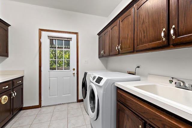 clothes washing area featuring independent washer and dryer, cabinets, sink, and light tile patterned floors