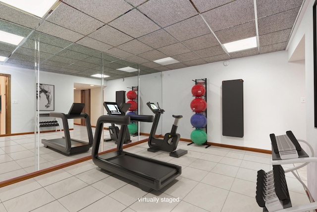 exercise room with a paneled ceiling and tile patterned floors