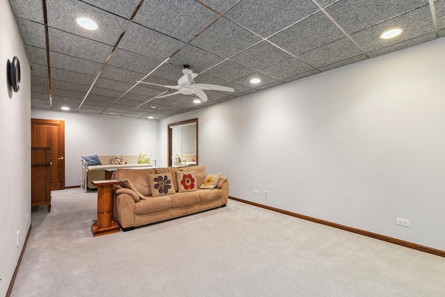 living room with ceiling fan, carpet, and a drop ceiling