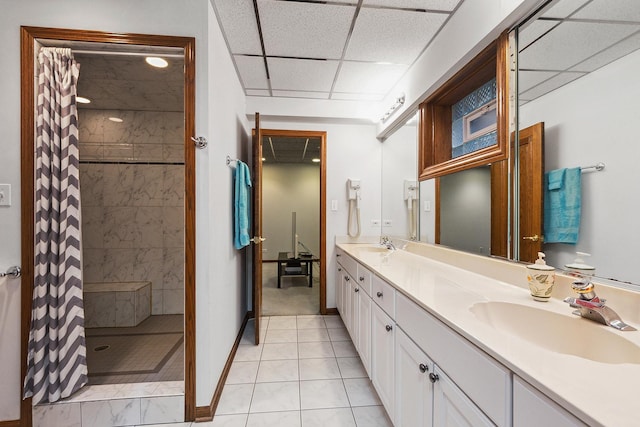 bathroom with a paneled ceiling, vanity, curtained shower, and tile patterned floors