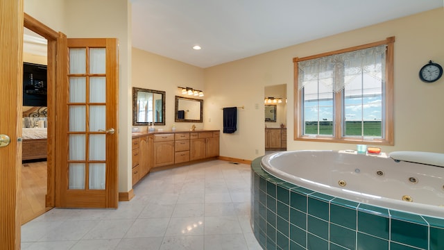 bathroom with vanity, a relaxing tiled tub, and tile patterned floors