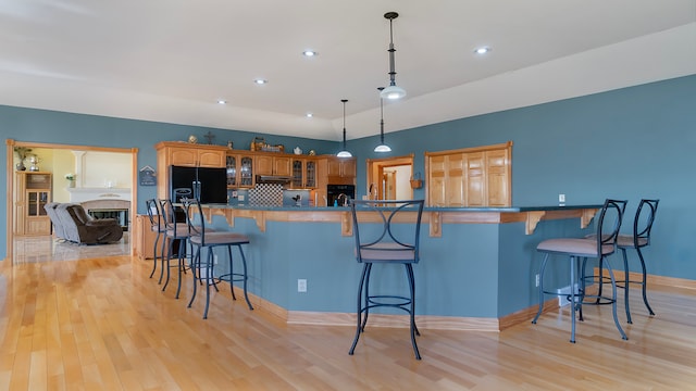 kitchen with a kitchen bar, kitchen peninsula, and black fridge