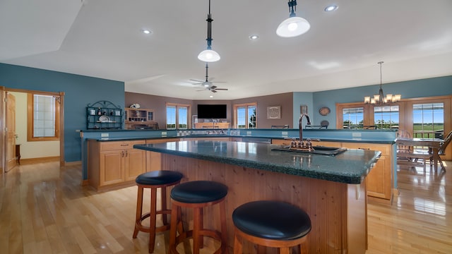 kitchen with light hardwood / wood-style flooring, kitchen peninsula, a breakfast bar, and a kitchen island