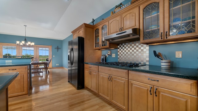 kitchen featuring light hardwood / wood-style flooring, decorative backsplash, black appliances, a notable chandelier, and decorative light fixtures