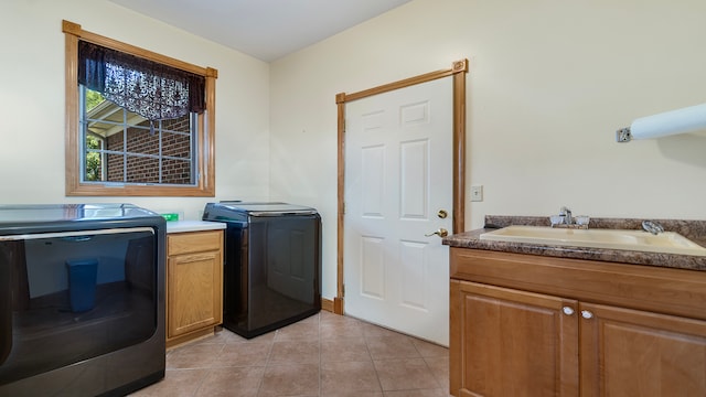 washroom featuring washer and clothes dryer, sink, light tile patterned floors, and cabinets