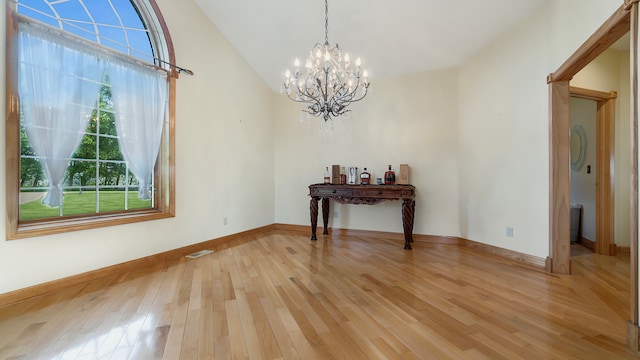 unfurnished dining area with vaulted ceiling, light hardwood / wood-style floors, and an inviting chandelier