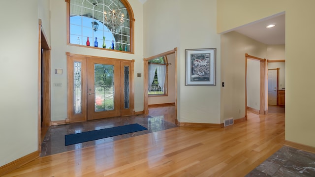 entryway featuring hardwood / wood-style floors and a towering ceiling