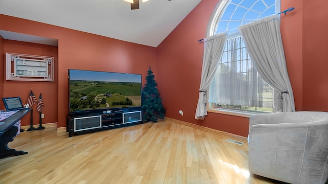 living room with vaulted ceiling, light hardwood / wood-style flooring, plenty of natural light, and ceiling fan