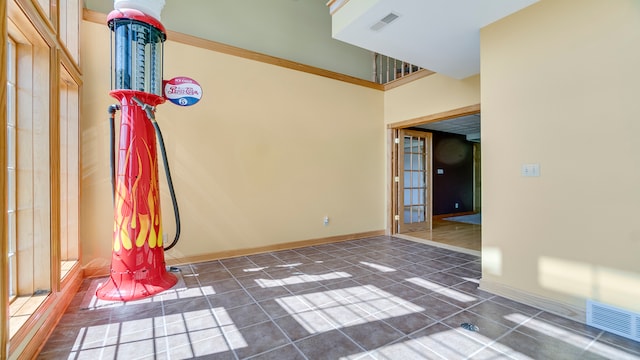 tiled spare room with ornamental molding