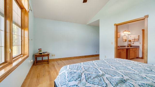 bedroom with light hardwood / wood-style flooring, lofted ceiling, ceiling fan, and ensuite bathroom