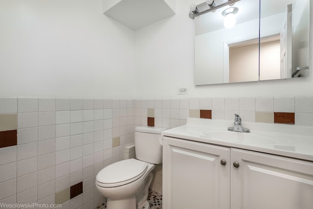 bathroom featuring vanity, tile walls, and toilet