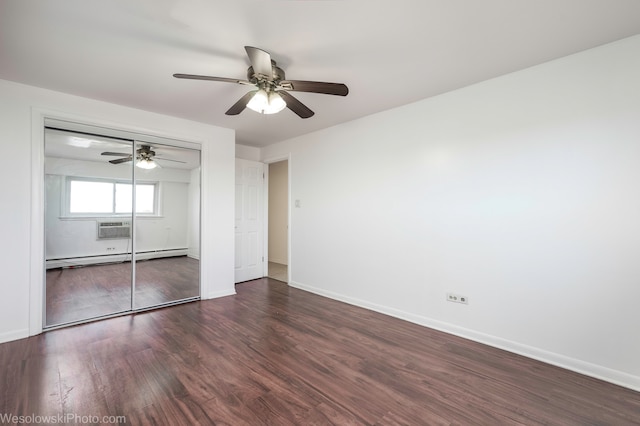 unfurnished bedroom featuring ceiling fan, a closet, dark wood-type flooring, and a baseboard heating unit