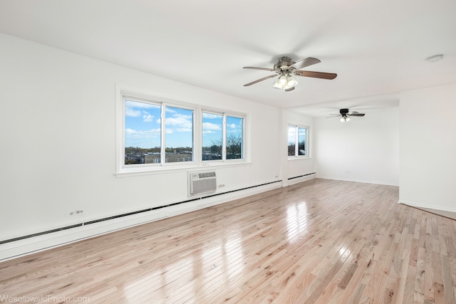 unfurnished room with light wood-type flooring, baseboard heating, an AC wall unit, and ceiling fan