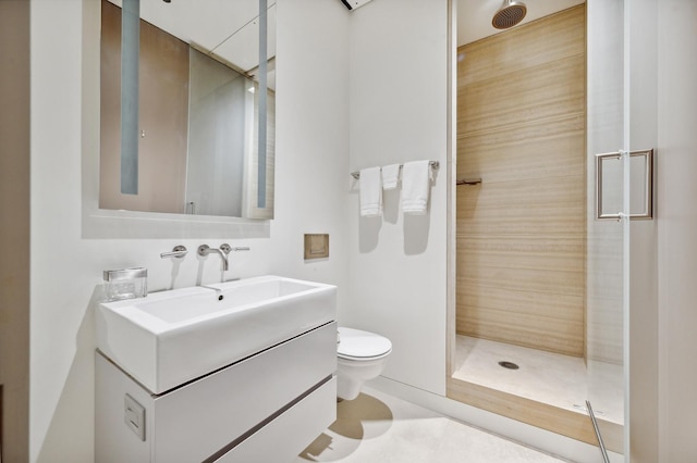 bathroom with a tile shower, tile patterned floors, vanity, and toilet