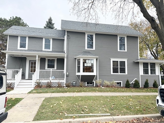 view of front of home featuring covered porch and a front yard