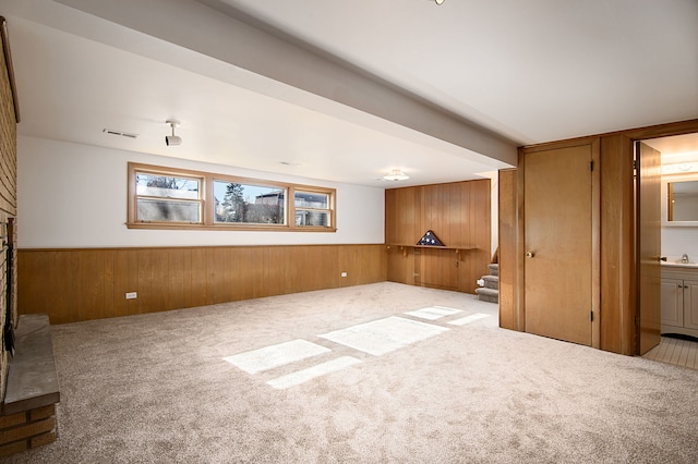 unfurnished living room with light carpet and wooden walls