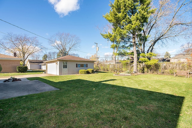 view of yard with a patio area, a garage, and an outdoor structure