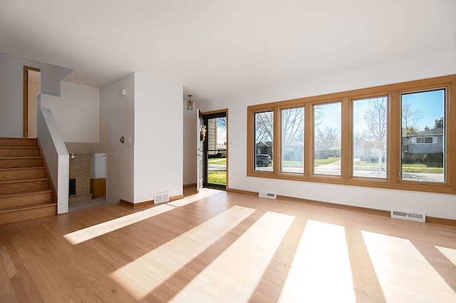 unfurnished room with a fireplace and light hardwood / wood-style floors