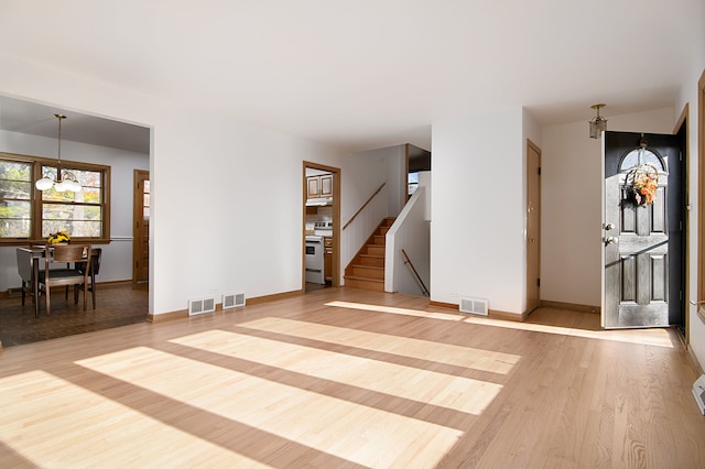 empty room with hardwood / wood-style floors and a notable chandelier