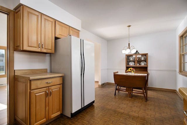 kitchen featuring dark parquet flooring, white refrigerator, decorative light fixtures, and a notable chandelier