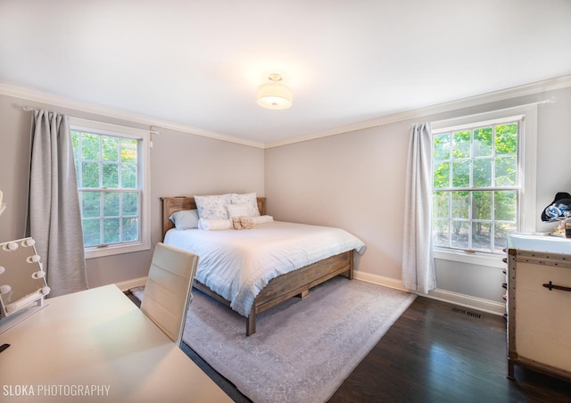 bedroom with ornamental molding, dark wood-type flooring, and multiple windows