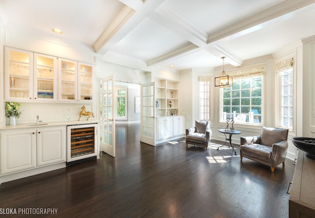 living area with coffered ceiling, beverage cooler, crown molding, wet bar, and beamed ceiling