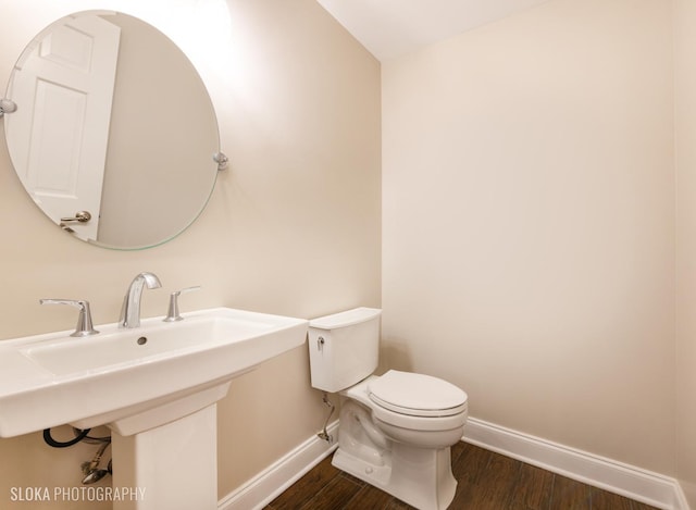 bathroom with toilet, wood-type flooring, and sink