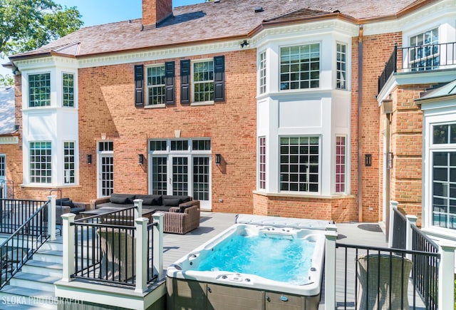 back of house featuring a wooden deck, an outdoor living space, and a hot tub