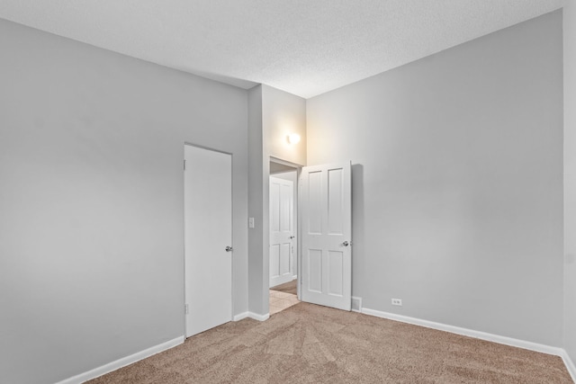 unfurnished bedroom featuring a textured ceiling and light carpet