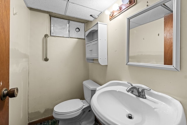 bathroom with a paneled ceiling, sink, and toilet