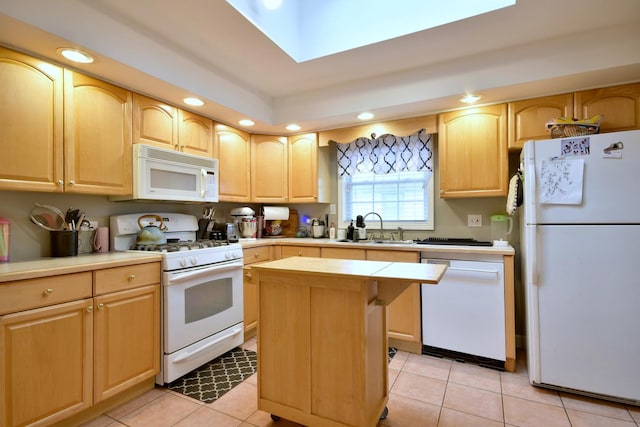 kitchen with light brown cabinetry, light tile patterned floors, white appliances, and a kitchen island