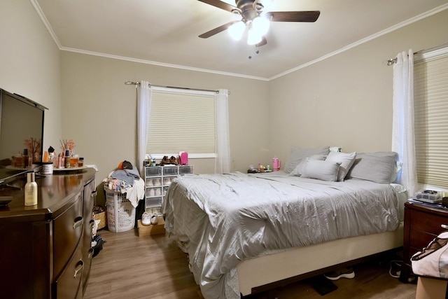 bedroom with hardwood / wood-style flooring, ornamental molding, and ceiling fan