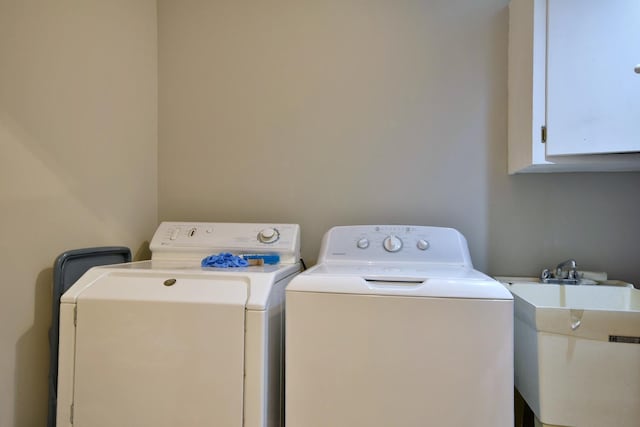 washroom featuring cabinets, sink, and washing machine and dryer