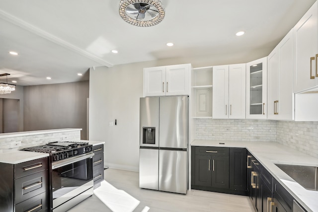 kitchen featuring decorative backsplash, light stone counters, stainless steel appliances, sink, and white cabinets